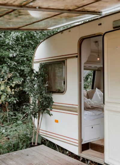 kleine caravan met open deur in het bos
