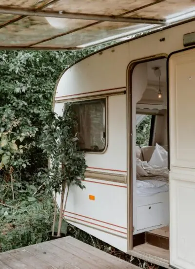 kleine caravan met open deur in het bos